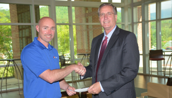Photo of Pepsi representative presenting a check to SCC president.
