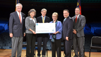 Group of people holding a large check.
