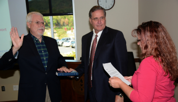 Two men look at woman talking