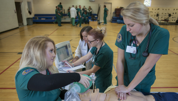 Two girls look at mannequin on table