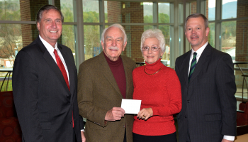 Three men and a woman pose for a photo inside a building on SCC's Jackson Campus.