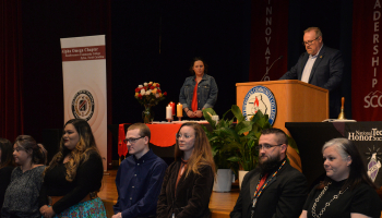 Inductees stand in front of the stage.