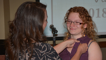 Instructor applies pin to a student's shirt