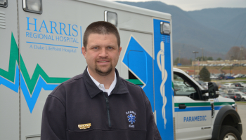 Man stands in front of an ambulance.