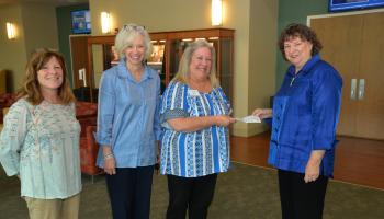 Three ladies present check to SCC representative