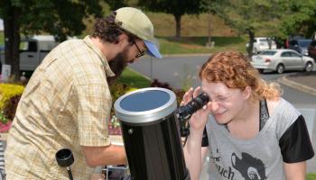 Young lady looks through a telescope during the 2017 total solar eclipse