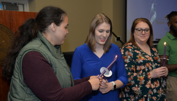 Students hold candles during a ceremony