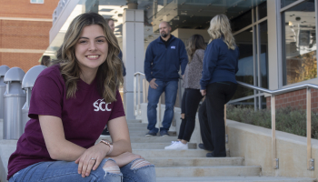 Student seated outside Health Sciences Center