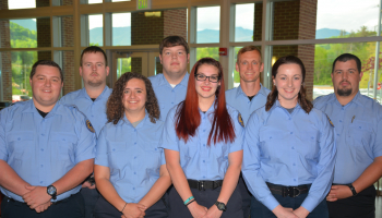 Eight students standing and smiling
