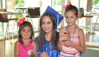 Yanez smiling with her two daughters
