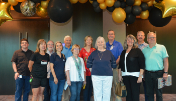 Event planning committee stands inside the space where this year's gala will be held.
