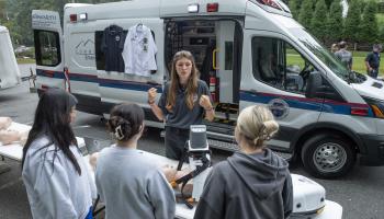 Student stands in front of ambulance