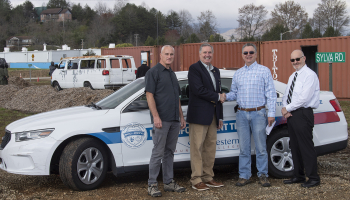 Four men stand in front of a law enforcement training vehicle in Franklin.