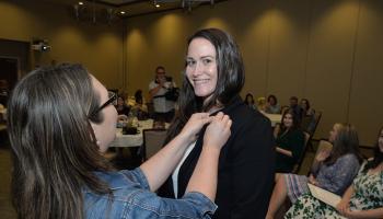 Student receives her pin from instructor Anna Walls
