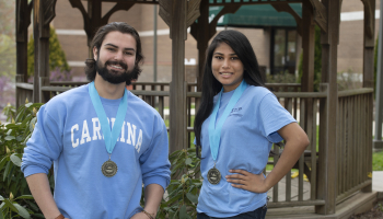 Students wearing UNC shirts stand in front of a gazebo