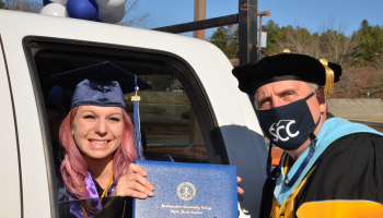 Woman receives diploma cover from SCC president