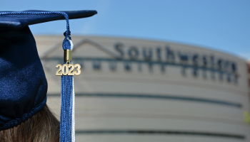 Graduate wearing cap in front of the Don Tomas Health Sciences Center