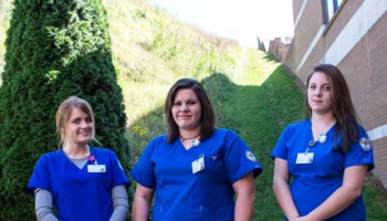 Photo of two graduates preparing to enter auditorium for the ceremony.