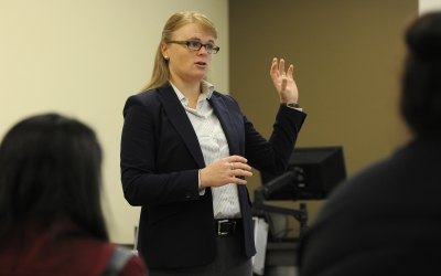 Woman speaks in front of a classroom