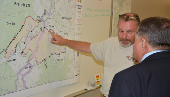 Two men look at map on wall
