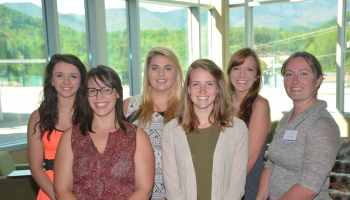Students smiling with hands in front of them