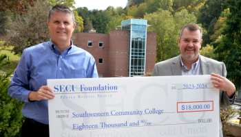 Two men hold a large check
