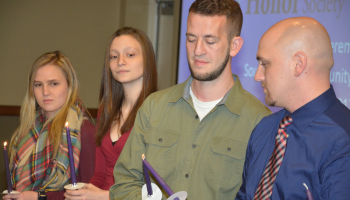 SCC students light candles as part of the ceremony