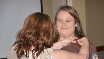 SCC Nurse Aide graduate receives pin from her program coordinator.