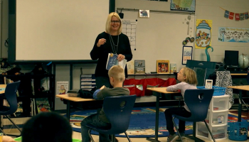Teacher speaks to elementary students in a classroom setting.