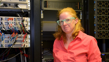 woman stands in front of computer equipment