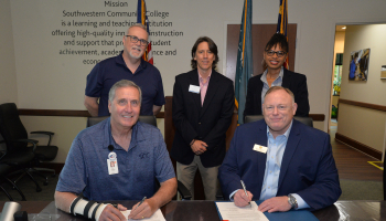 Five people at a signing ceremony