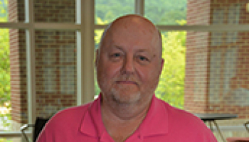 Photo of SCC criminal justice technology program coordinator Tim Coffey, holding a certificate that recognizes his 35 years of service to the state of North Carolina.