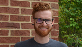 Man holds sign thanking donors for helping him go to college.