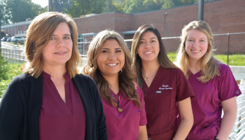 Four ladies stand outdoors