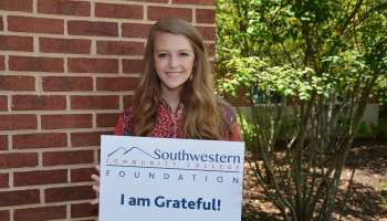 Student holds 'thank you' sign