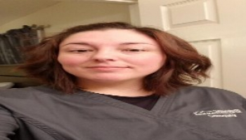 Young woman poses in sonography scrubs