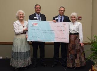 Group of people hold large check