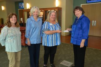 Three ladies present check to SCC representative