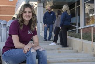 Student seated outside Health Sciences Center