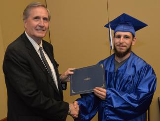 Southwestern President Dr. Don Tomas (left) presenting a diploma to Christian Rodriguez of Cherokee.