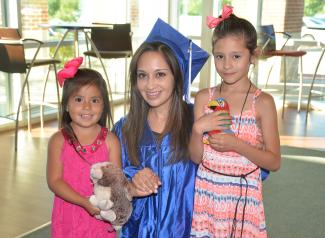 Yanez smiling with her two daughters