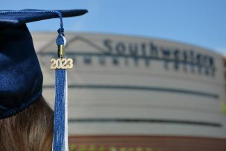 Graduate wearing cap in front of the Don Tomas Health Sciences Center