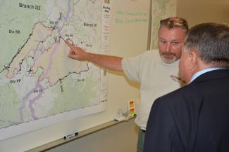 Two men look at map on wall
