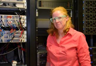 woman stands in front of computer equipment