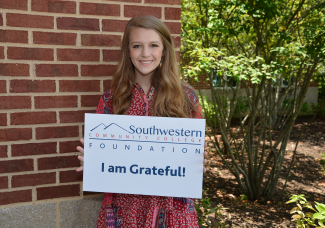 Student holds 'thank you' sign