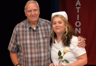 Nursing graduate poses with her family member